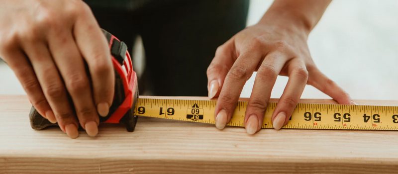 b10 Female carpenter measuring the lumber - Image by © rawpixel